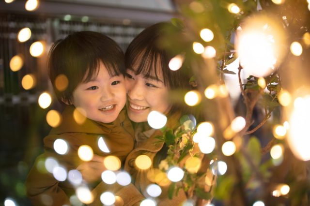 A mom and young daughter among Portland Christmas lights displays smiling