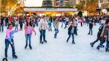 families and kids ice skating at an outdoor rink in atlanta during the holidays