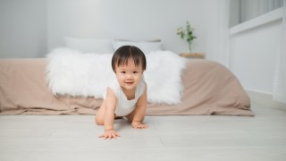 a baby crawling on the floor, now is the time to start babyproofing
