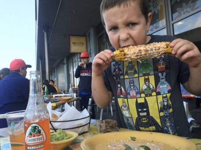A boy eats corn on the cob at San Francisco's Ferry building
