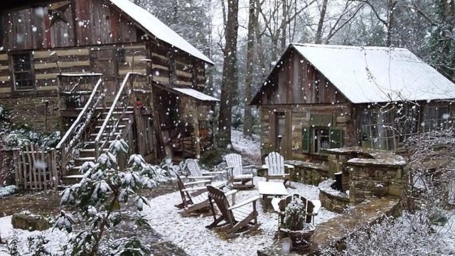 two cabins near atlanta are covered in snow and there's a firepit and chairs in between the two mountain cabin rentals