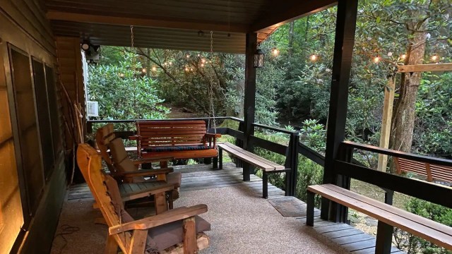 a swing and covered porch of a cabin rentals near Atlanta with a river in the distance