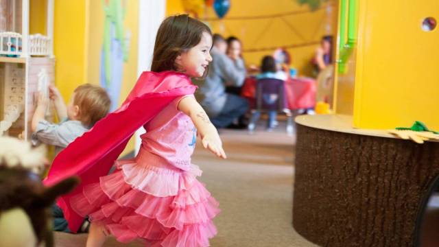 A girl plays dress up in an indoor playspace