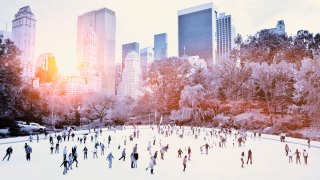 crowd of people ice skating outside at rink in Central Park in New York City