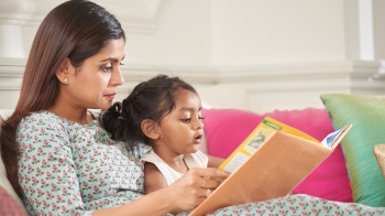 mom and daughter reading a book for a toddler