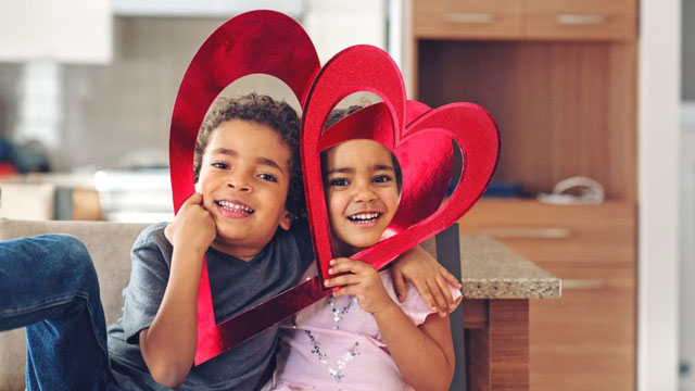 cute kids with paper hearts smiling at Valentine's Day jokes for kids