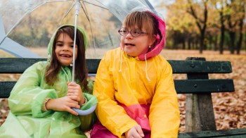 two girls sitting at the park on a rainy day enjoying a March birthday