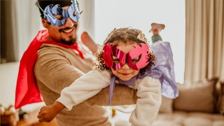 a little girl and her dad playing superhero in a fun dress-up game for toddlers