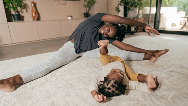 a toddler girl and her mom doing yoga, one of the great games for toddlers with lots of energy