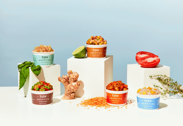 Five different colored containers from Tiny Organics are filled with meals for children