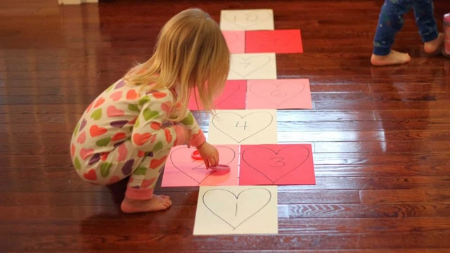 a picture of a girl playing heart hopscotch, a fun Valentine's Day game