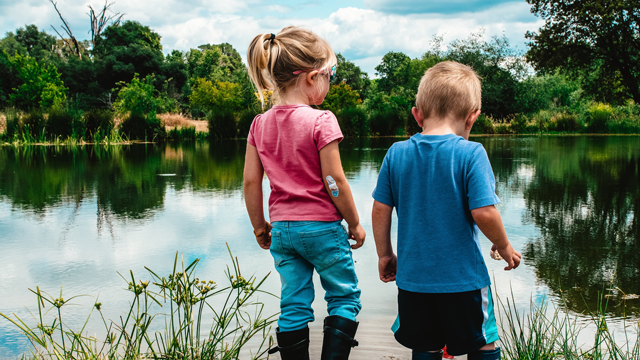 boy and girl by a pond