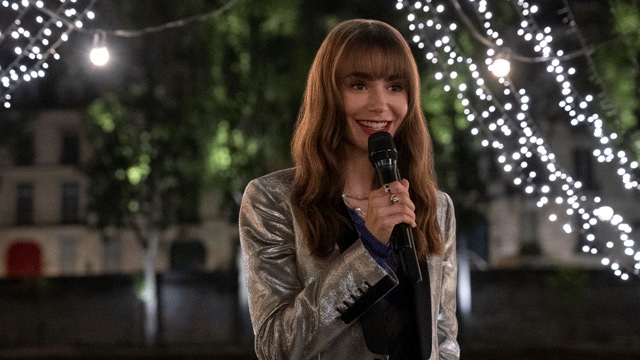 emily in paris woman holding a microphone with lights in the background, adult shows on netflix
