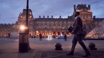 a man walks briskly outside the Louvre in Paris, adult shows on netflix lupin