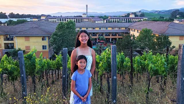 Two girls stand in front of a vineyard at Meritage Resort in Napa