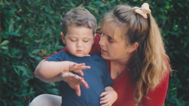 mom and toddler looking at hands