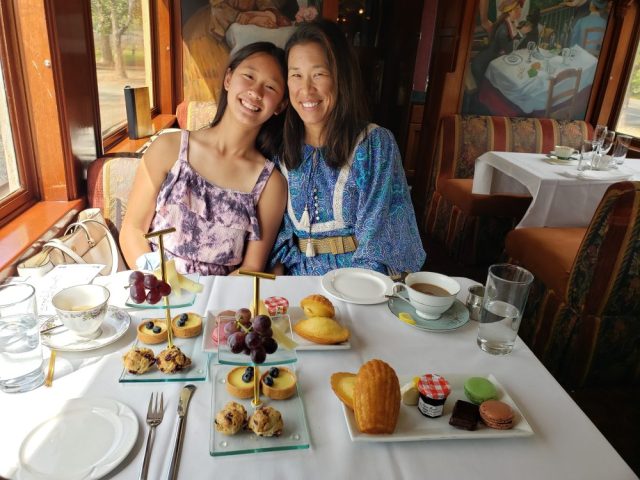 An Asian mother and daughter enjoy a special afternoon tea onboard the Napa Valley Wine Train