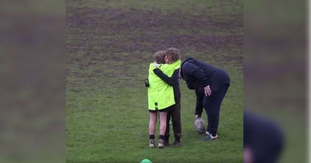 rugby kid pep talk, two rugby players huggung