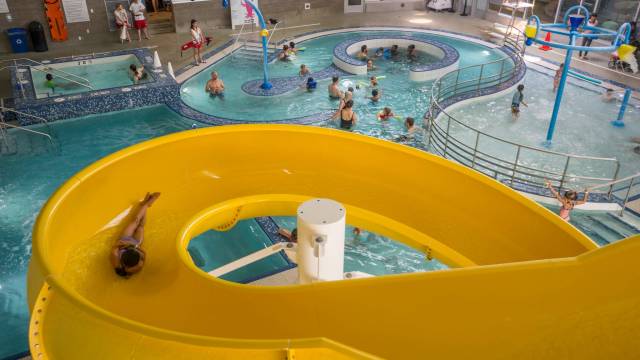 a girl goes down a waterslide at a seattle indoor swimming pool