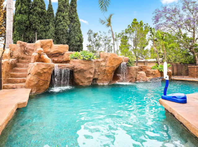 pool with faux rock walls, waterfall, and slide.