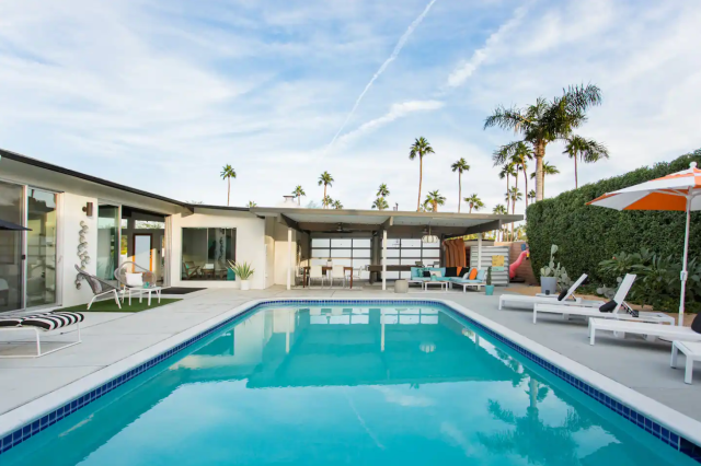 Pool with sitting area and covered patio with pool table near Palm Springs