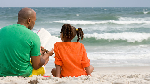 dad and daughter reading on the beach, a fun beach activity