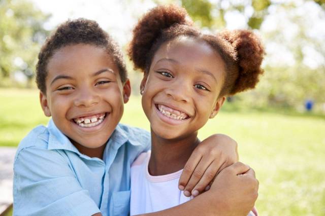 boy & girl siblings smiling and hugging - best sibling names