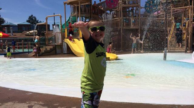 a boy poses at wild wave theme and water park on a sunny day