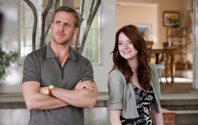 Ryan Gosling stands with his arms crossed next to Emma Stone