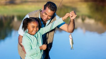 a dad and daughter catch a fish