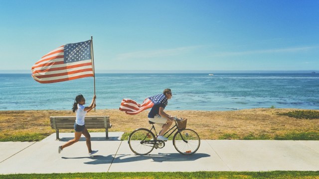 man riding a bike wearing american flag