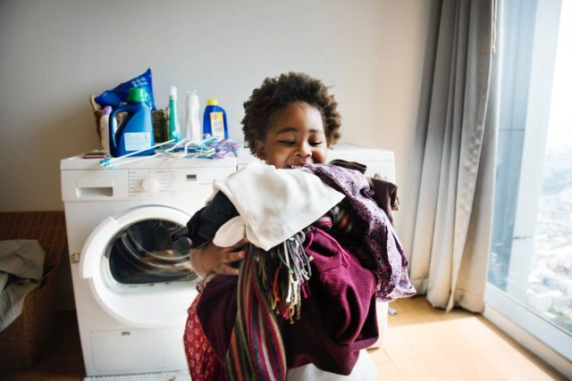 child taking laundry from the dryer - baby hacks