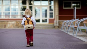 little boy walking alone to school