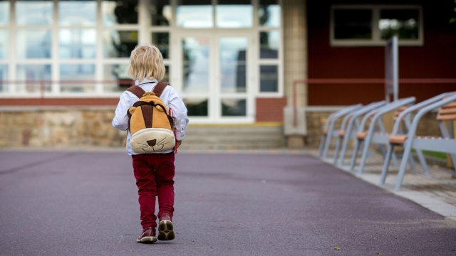 little boy walking alone to school