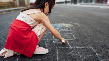 little girl playing sidewalk games