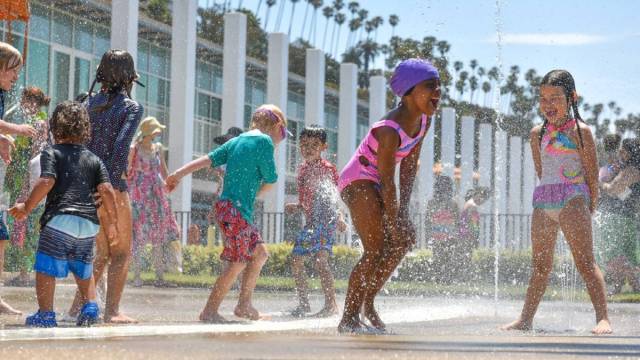 children playing in the water in swimsuits at a Los Angeles splash pad park