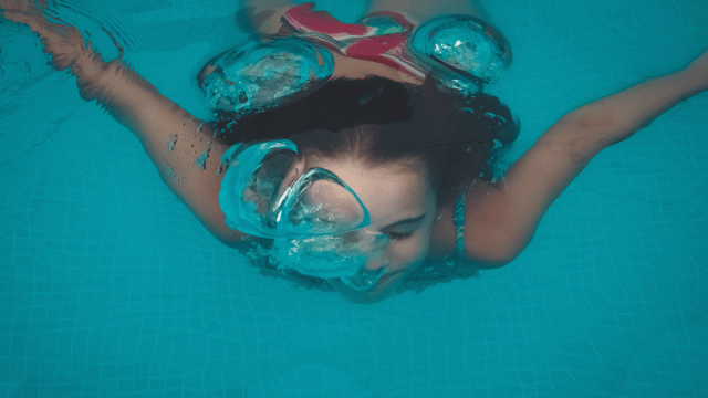swimming pool games. A girl swimming under water