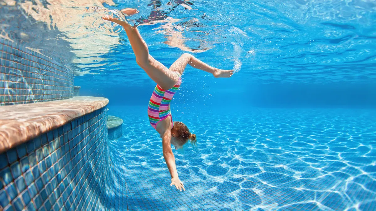 Swimmer Teen Boy Diving Fish Style Into The Swimming Pool Stock
