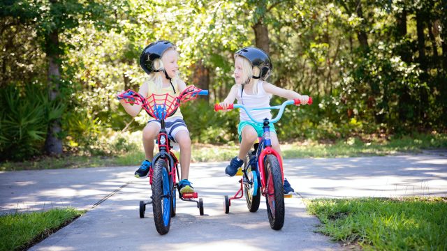 two kids riding bikes outside