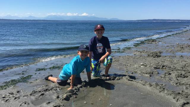 two boys dig in the sand at one of seattle sparyparks wading pools best beaches