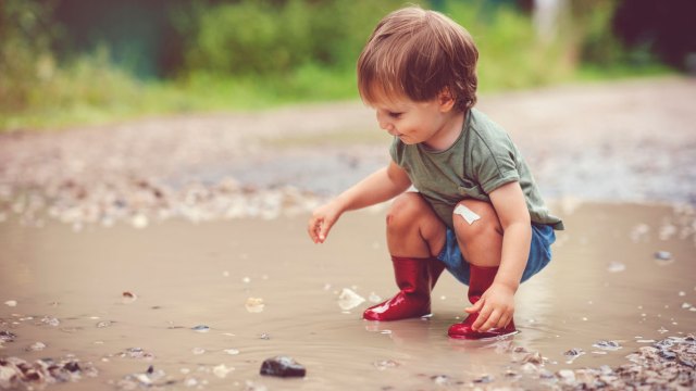 happy kid playing in a puddle