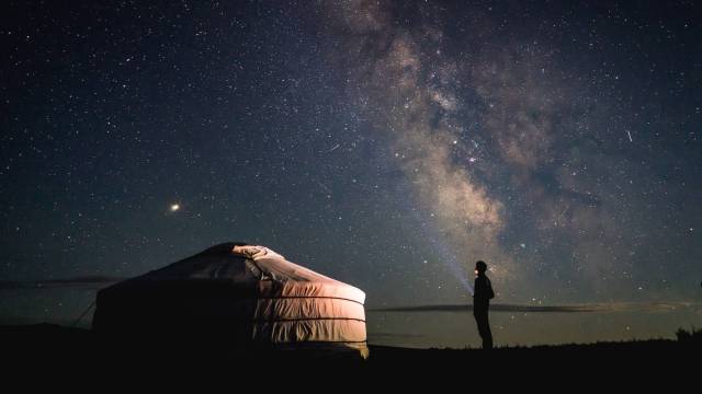 a person stares at the night sky during a yurt camping experience