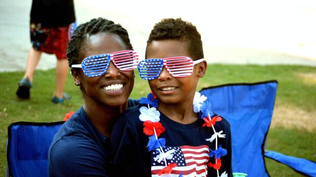 a mom and son watch a fourth of july seattle parade