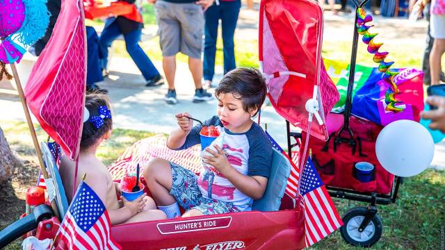 kids in a fourth of july parade decorated wagon