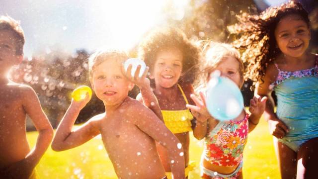 kids throw water balloons during family activities this month
