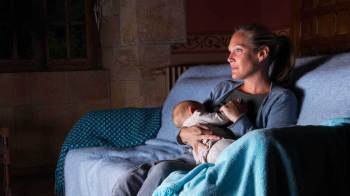 woman breastfeeding on couch at night