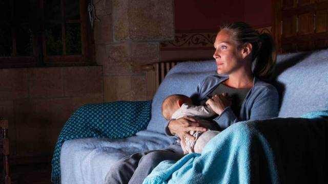 woman breastfeeding on couch at night