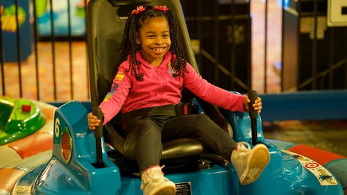 a girl on a bumper car at an indoor playgroud near dc, adventure USA