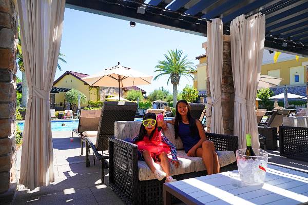 Two girls sit at a poolside cabana at Napa's Meritage Resort & Spa