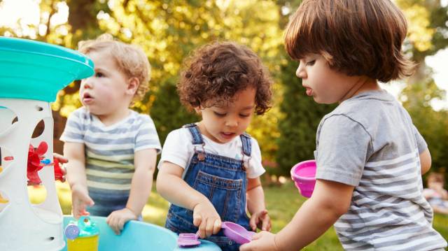three kids play at a water table outside, a family activities this month